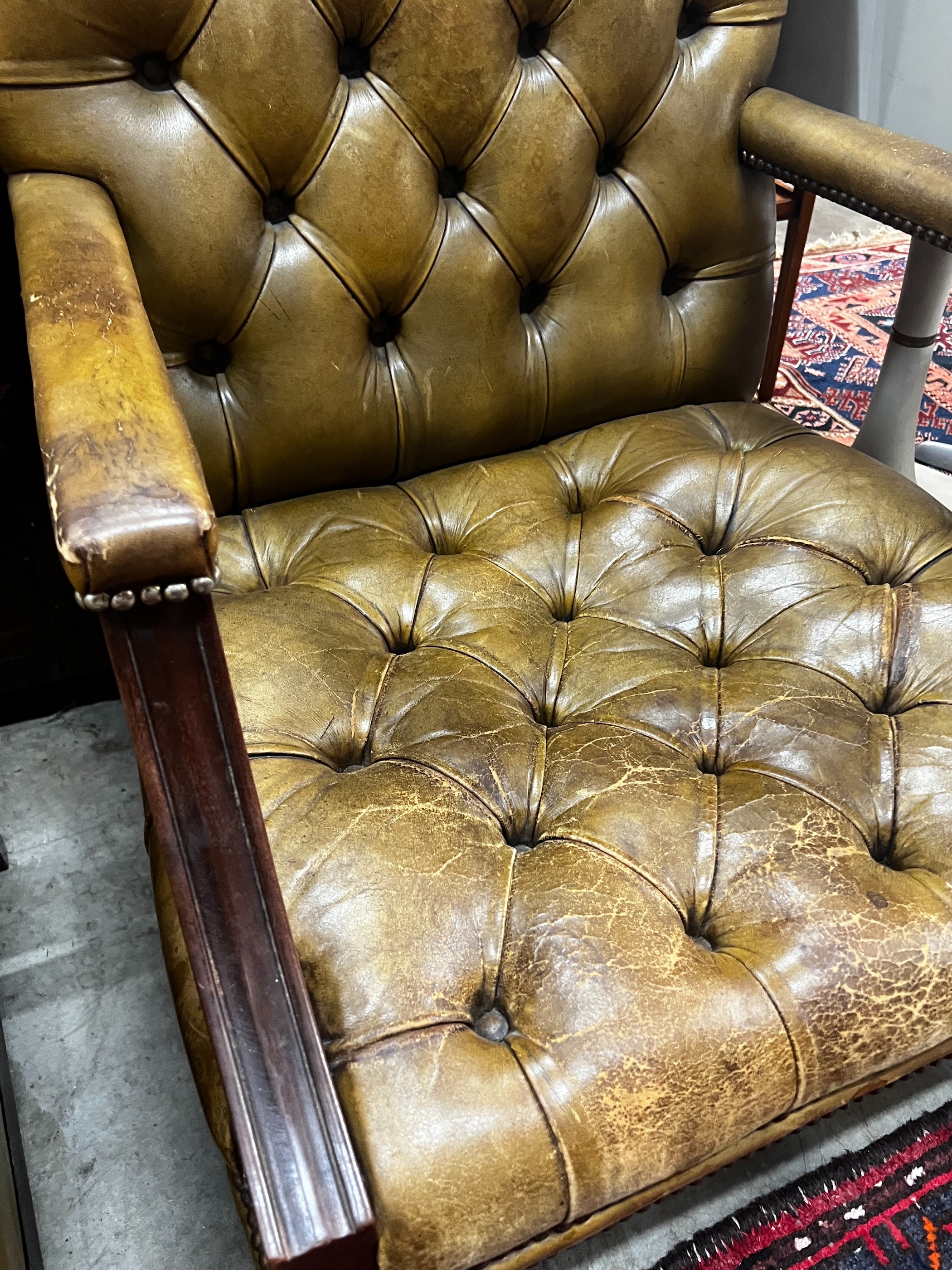 A George III style buttoned green leather library chair, width 64cm, depth 58cm, height 97cm